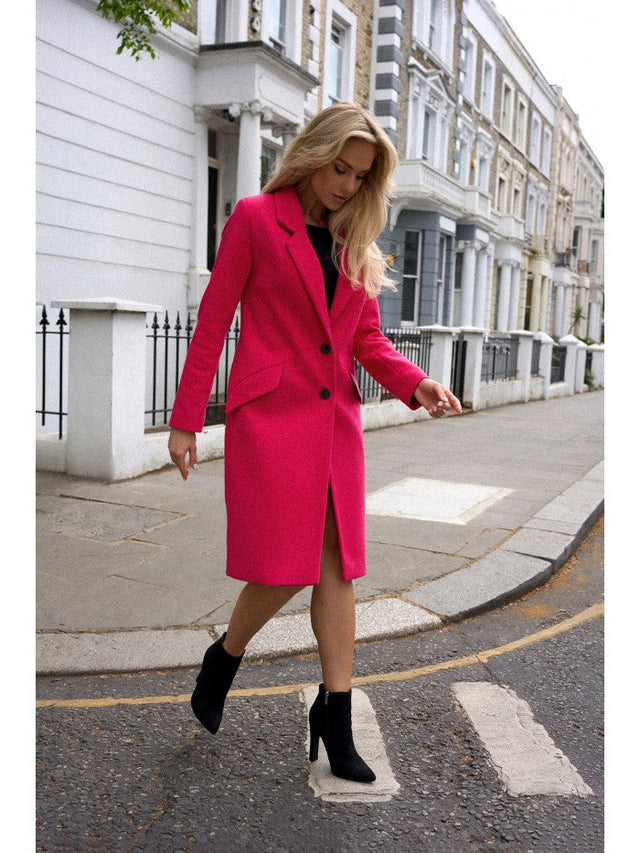 Fashionable model wearing a bright pink coat as a statement coats option on a city street