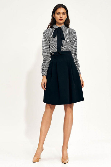 Elegant houndstooth skirt styled with a classic blouse and heels for a chic look